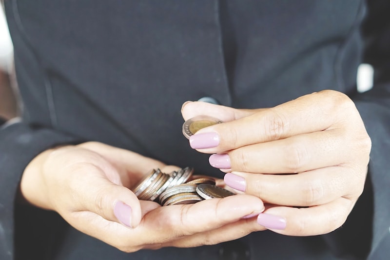 woman counting coins pink fingernails