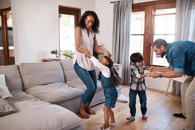 family dancing in a living room together.