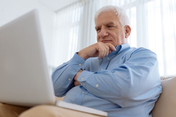 Image of someone sitting on the couch with their computer, thinking. What’s That Sound Coming From My Furnace?