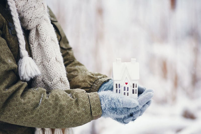 Person holding ceramic house in hands contemplating a zone control system. Ben's Heating & Air Conditioning blog image.